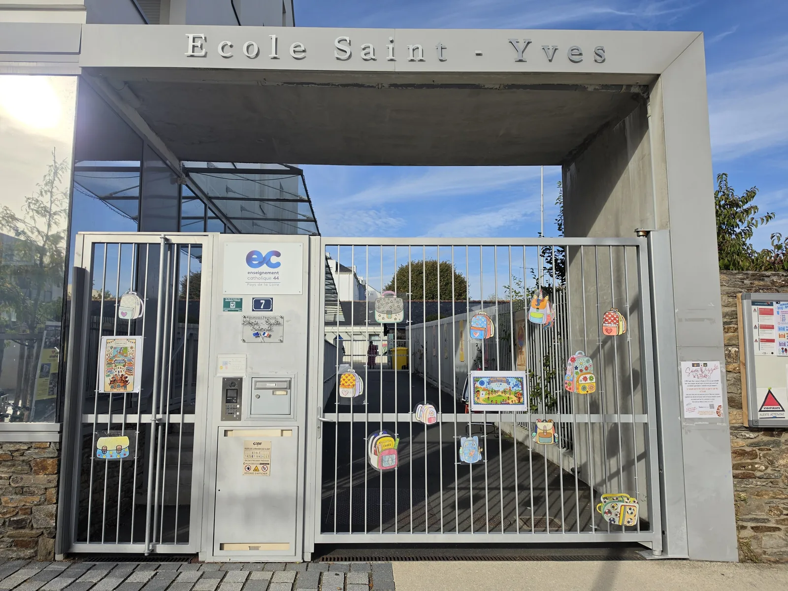 Le portail de l'école Saint-Yves, décoré de cartables dessinés par les enfants