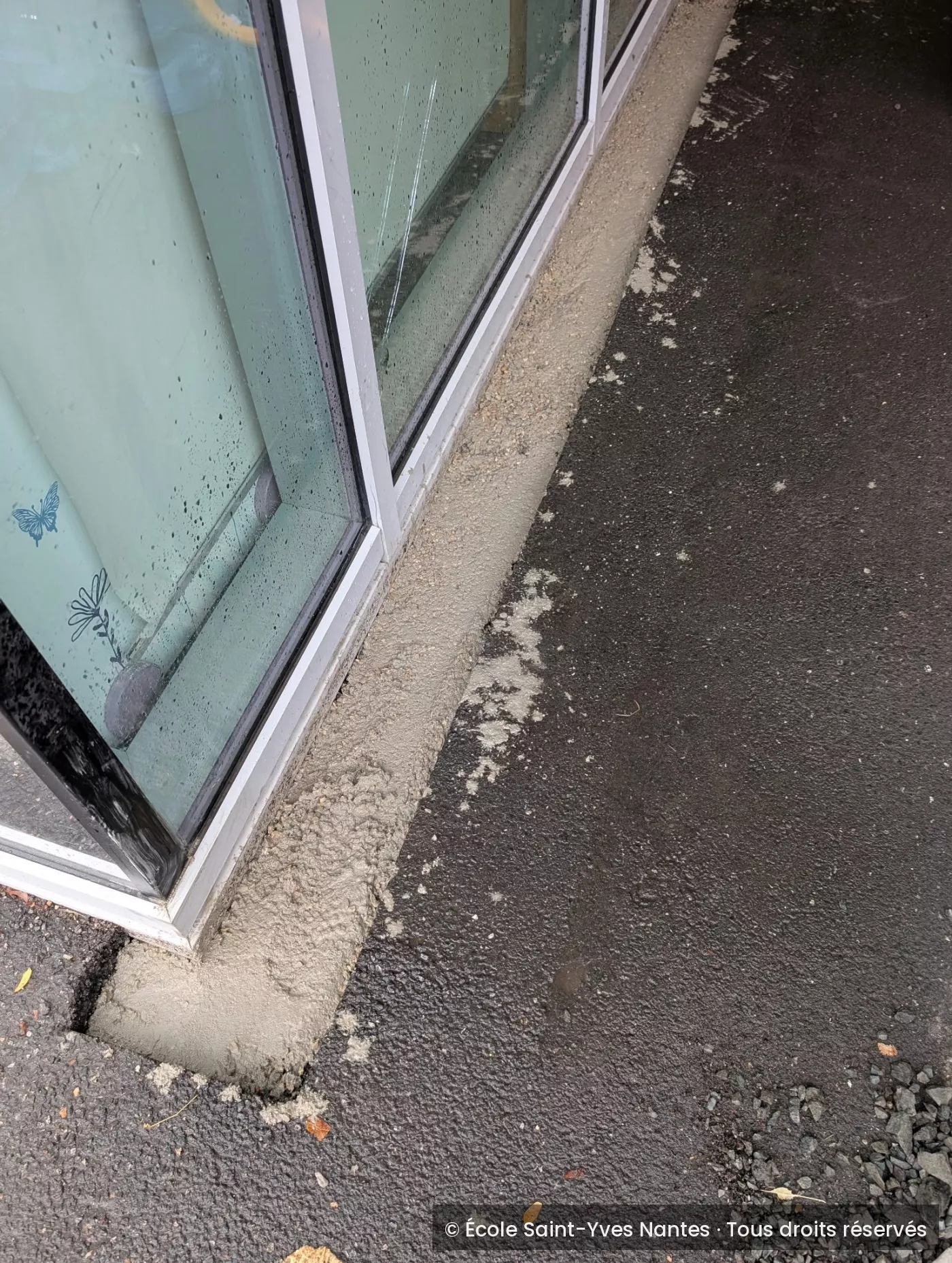 Bande de béton refaite le long des baies vitrées du préau